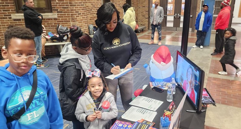 A family signing in at the Legacy North Foundation resource table