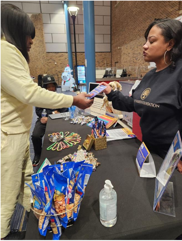 Legacy North Foundation volunteer handing diabetes prevention materials to an attendee