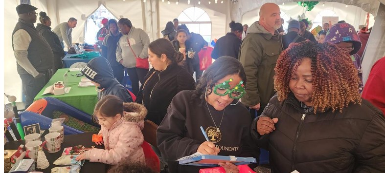 Legacy North Foundation volunteer helping a family at Christmas in the Village